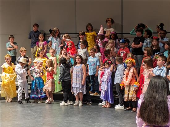 Grades 1-3 performing on stage.