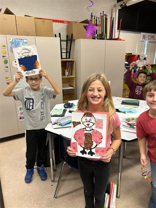 Students holding paper turkeys they made.